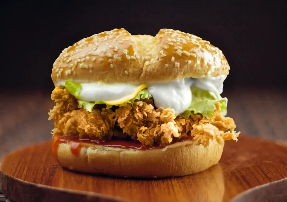 Crispy chicken burger on a wooden board