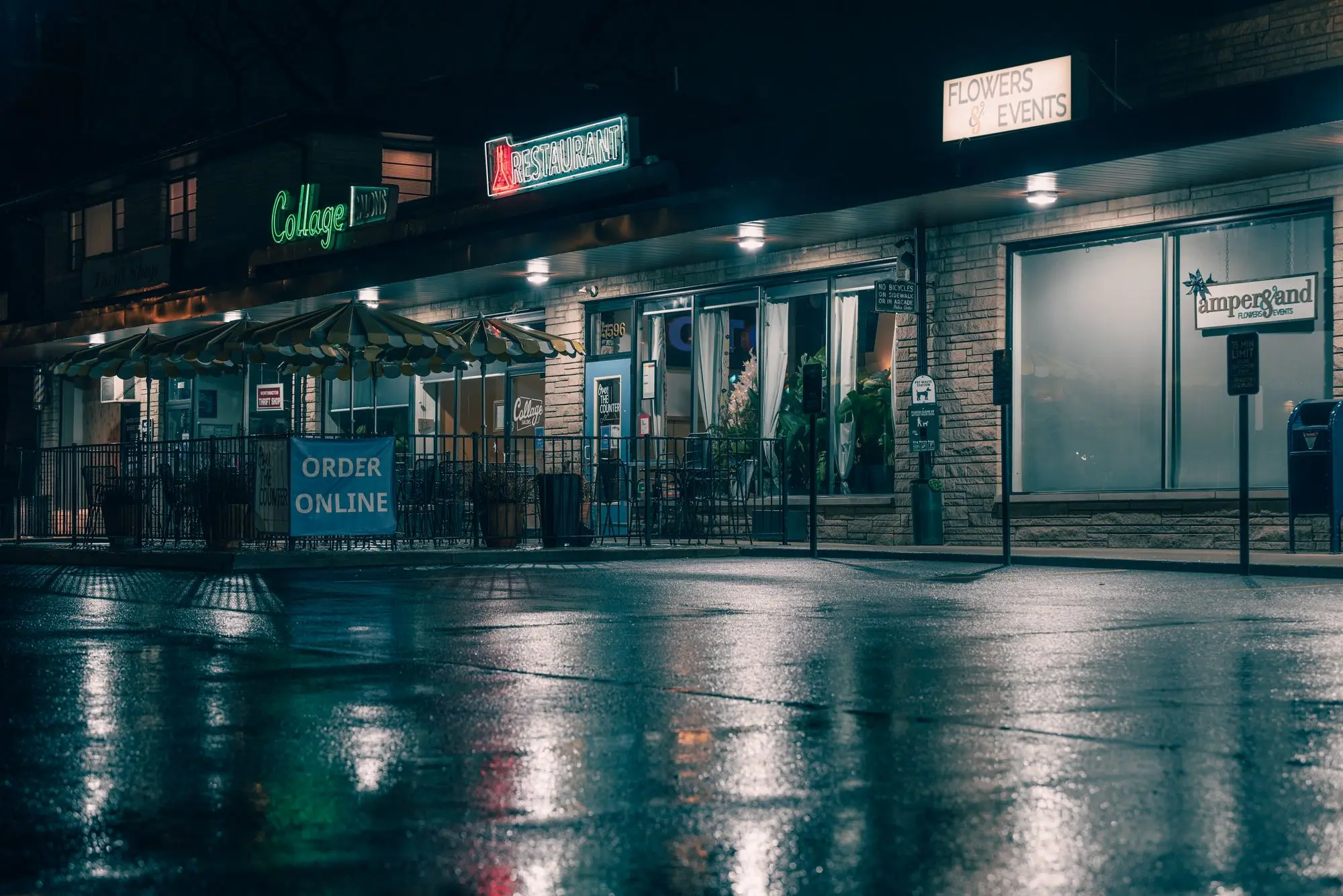 Restaurant row reflected on a wet street at night